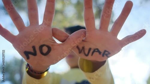 Child's hands open, bearing the message 'No to War.' Anti-war, pacifism, against arms sales, and violence prevention. Symbolizing victims of war, especially civilians and children. Embracing Peace Day photo