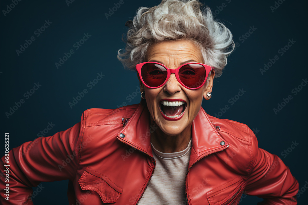Cheerful senior woman wearing sunglasses and bright red jacket with smile on her face, eldery people trendy lifestyle and fashion. Cheerful senior woman wearing sunglasses and bright red jacket with smile on her face, eldery people trendy lifestyle and fashion.