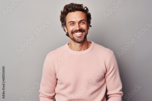 Portrait of a glad man in his 30s wearing a cozy sweater against a pastel gray background. AI Generation