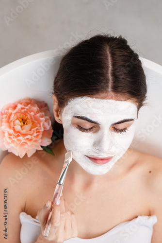 The girl applies a cosmetic mask in the bathroom