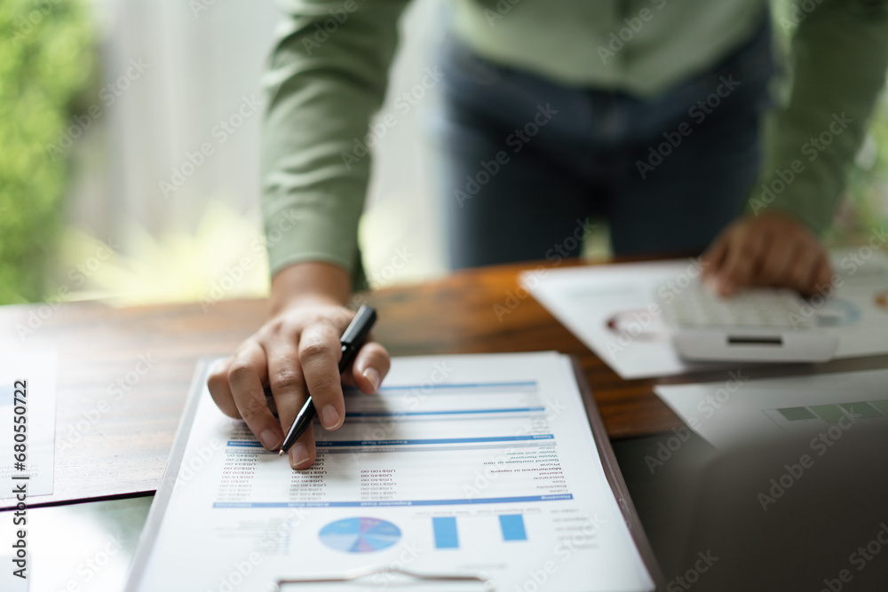 Female accountant checking finance document and calculate profit for accounting finance of business Female accountant checking finance document and calculate profit for accounting finance of business