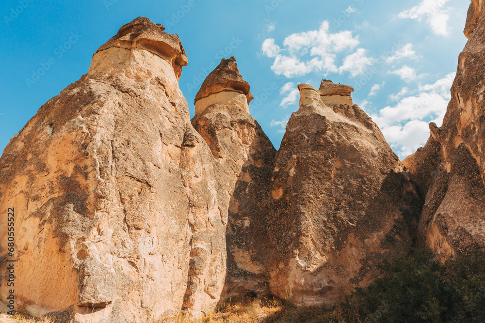 Captured in Cappadocia, these whimsical fairy chimney rock formations, set against a backdrop of blue skies and wispy clouds, tell a story of natural history and wonder.
