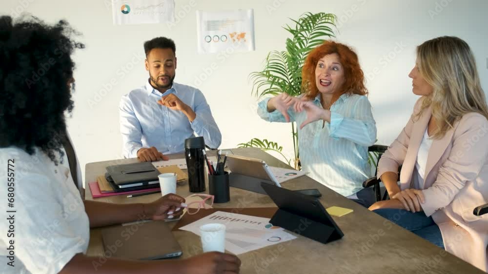 Company CEO talking with sign language translator for inclusion in a meeting at a coworking office.