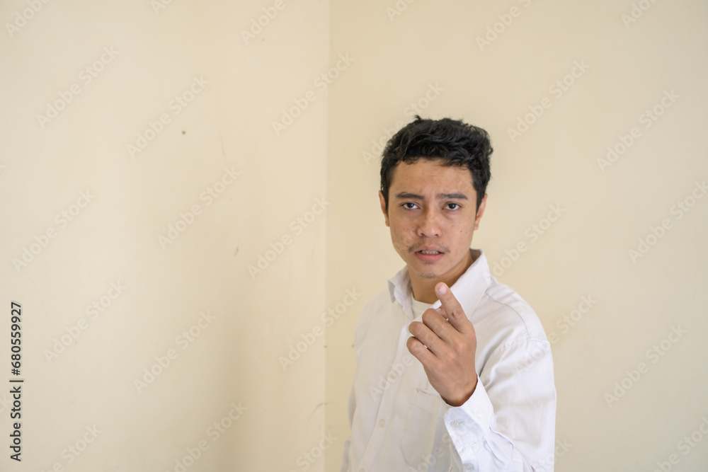 Indonesian man wear white clothes surprised looking to camera. The photo is suitable to use for man expression advertising and fashion life style. Indonesian man wear white clothes surprised looking to camera. The photo is suitable to use for man expression advertising and fashion life style.