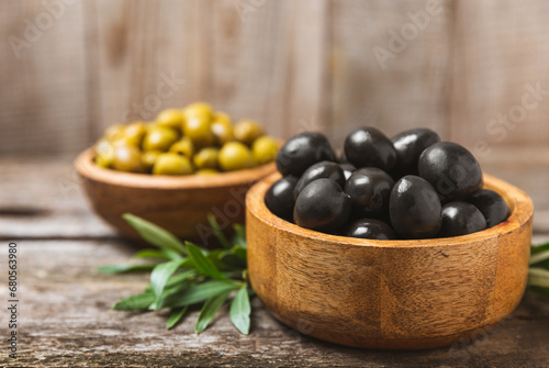 Fototapeta Naklejka Na Ścianę i Meble -  Green and black olives on a white wooden background. Various types of olives in bowls and olive oil with fresh olive leaves. Copy space. Place for text. Mediterranean food. Vegan.