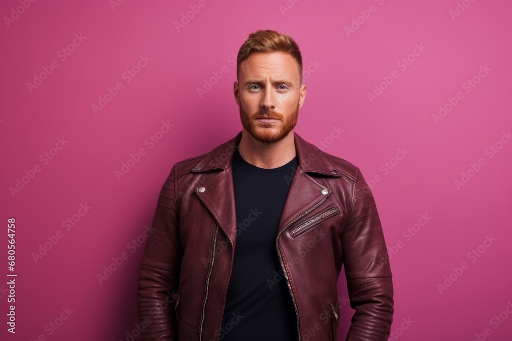 Fototapeta premium Portrait of a content man in his 30s sporting a classic leather jacket against a solid pastel color wall. AI Generation
