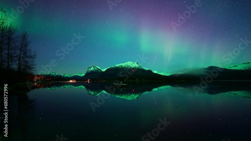Shy aurora dancing above crystal clear waters in lake Vatnvatnet in Bodø in October. photo