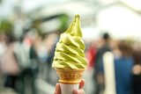 Matcha green tea soft serve ice-cream in waffle cone which is holded on person hand. Ready to eating sweet food.