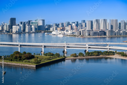 View of Tokyo Skyline and Tokyo Bay with Rainbow Bridge on  a clear blue sky day © clement