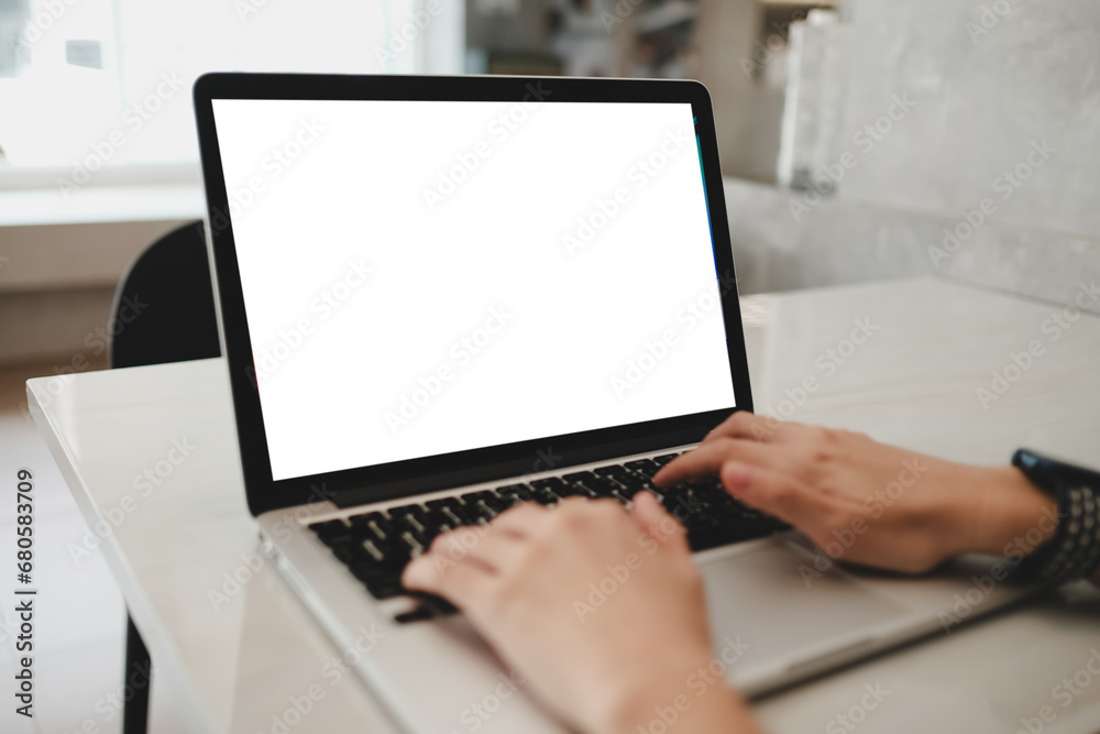 Mockup image of a woman using laptop with blank white screen on wooden table in modern loft cafe Mockup image of a woman using laptop with blank white screen on wooden table in modern loft cafe