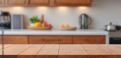 Wooden table on blurred kitchen bench background. Empty wooden table and blurred kitchen background for display or montage your products © German