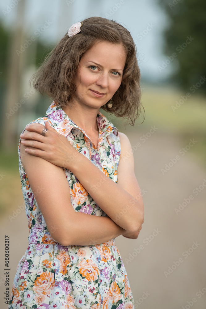 Fototapeta premium Beautiful young girl in a summer dress outdoors in the village.