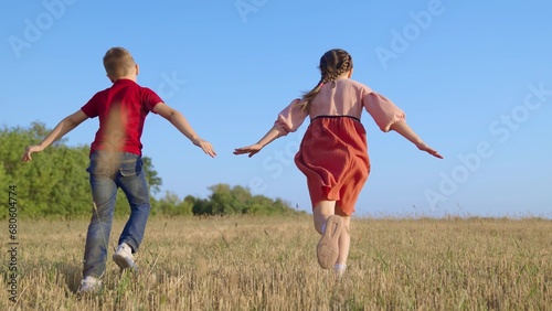 Kids running  sky. Happy family. Children boy  girl play in park  Friends run together raising their hands  dream is to fly to travel.Creative imagination of children  concept of active play in nature