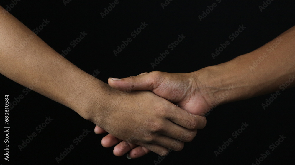 Close up two man shaking hand as agreement on black background. Close up two man shaking hand as agreement on black background.