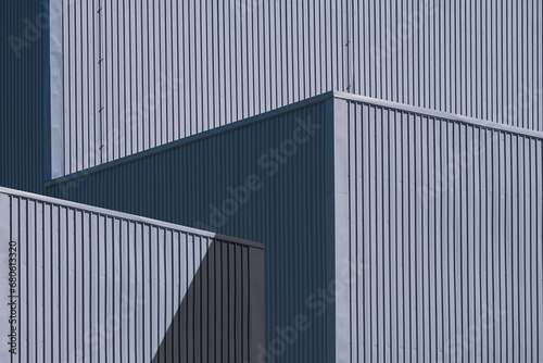 Gray corrugated Metal Factory Buildings with sunlight and shadow on Steel Wall surface in Minimal style, Perspective side view