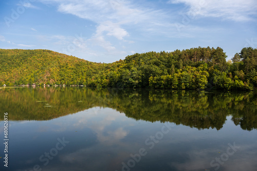 Spring landscape with beautiful clouds in the blue sky. Picturesque view of nature wild lake.  Incredible view on mountains lake. Amazing natural Background.
