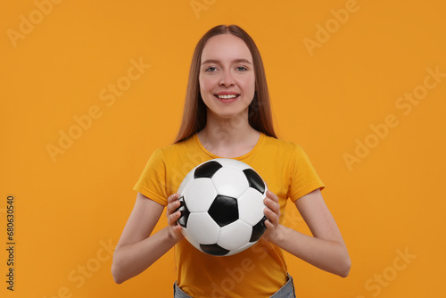 Happy sports fan with ball on yellow background © New Africa
