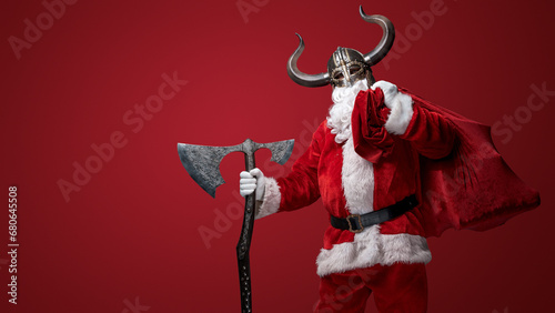 Santa Claus in a Viking helmet, wielding a decorative axe, combining tradition and fantasy photo