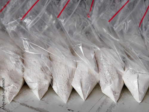 A large number of transparent sachets filled with white powder. White powder packaged in small sachets. photo