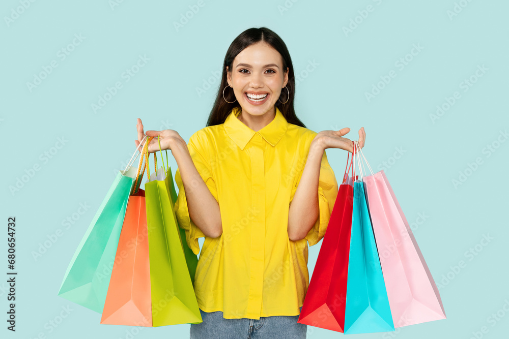 Happy woman showing bunch of colorful shopping bags