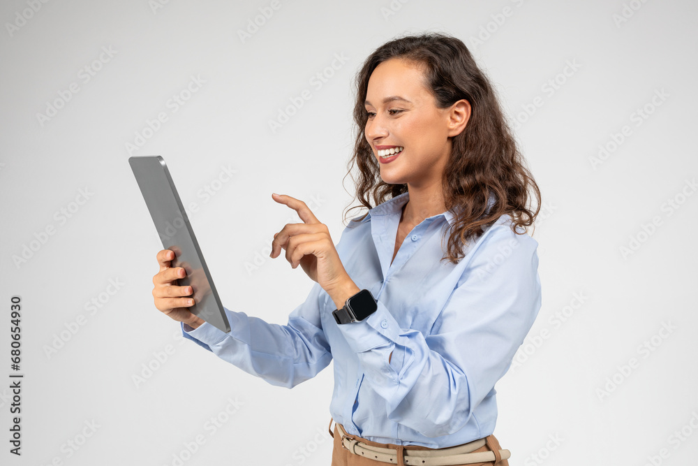Glad inspired caucasian young businesswoman use tablet, typing finger on screen Glad inspired caucasian young businesswoman use tablet, typing finger on screen