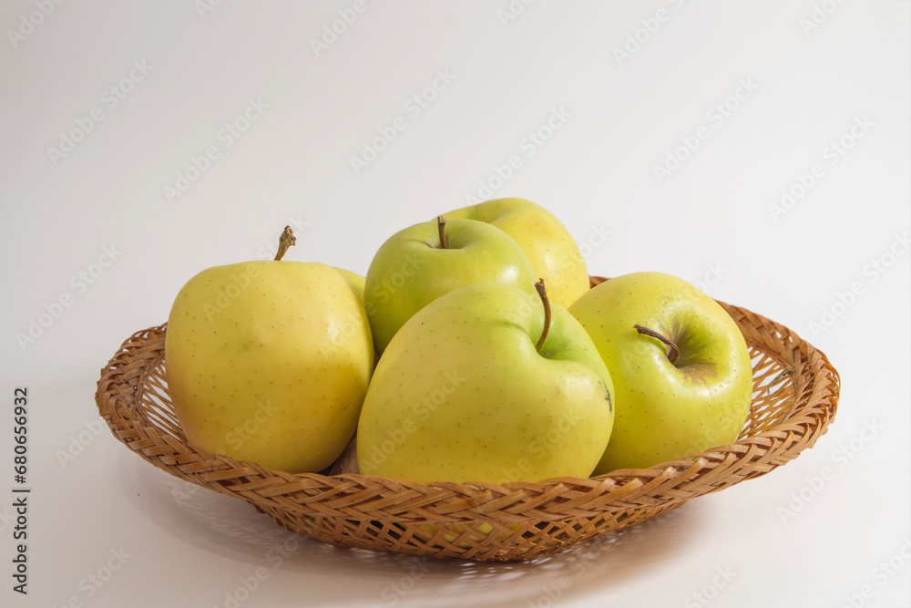 Basket with yellow apples golden variety, isolated on white background Basket with yellow apples golden variety, isolated on white background