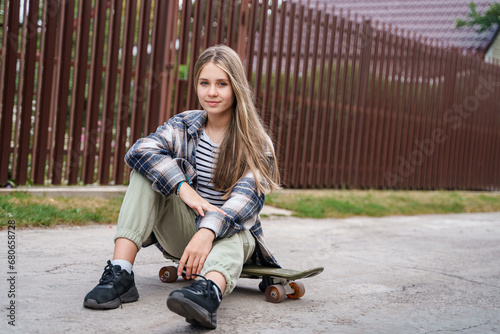 A cheeky cool teen girl in a plaid shirt is sitting on a skateboard, teenage hobbies and problems