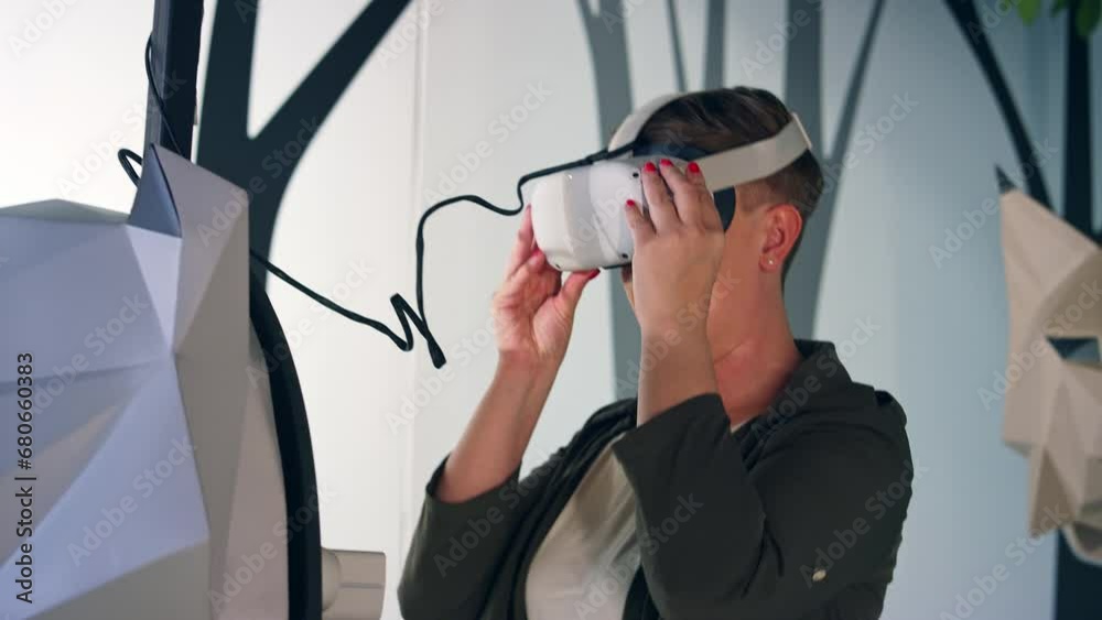 Smiling and delighted young woman enjoying VR experience, using virtual reality glasses in the natural history museum playroom, low angle shot. Smiling and delighted young woman enjoying VR experience, using virtual reality glasses in the natural history museum playroom, low angle shot.