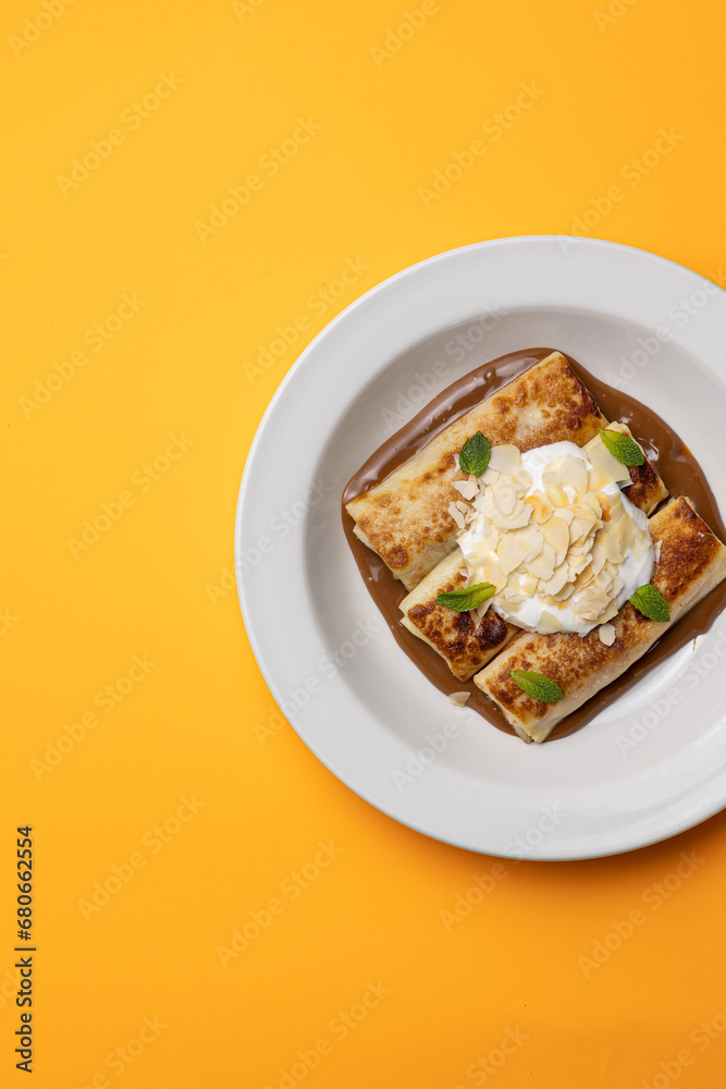 Ukrainian cuisine. pancakes with sour cream and almond flakes . Close-up Ukrainian cuisine. pancakes with sour cream and almond flakes . Close-up