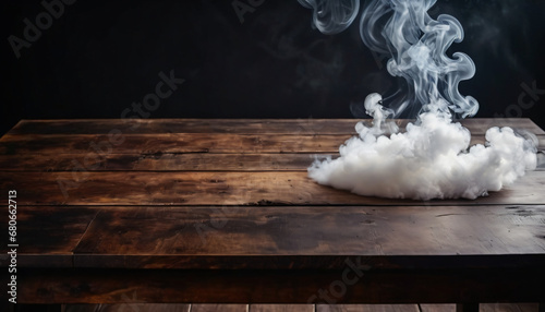 White cloud of smoke on a wooden table. Smoke on a black background.
