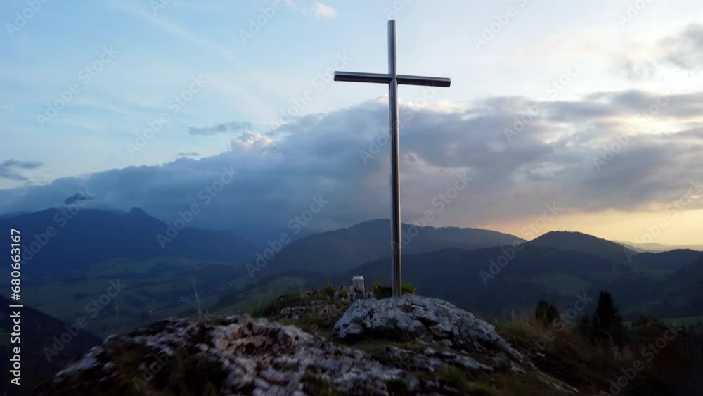 Aerial view of a religious Christian steel cross on a hill in the mountainous countryside, in sunset Aerial view of a religious Christian steel cross on a hill in the mountainous countryside, in sunset
