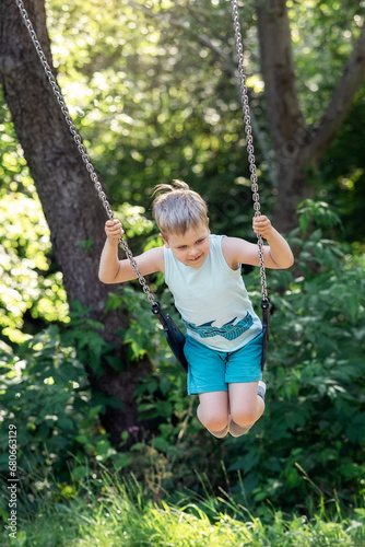 Happy child swings around on sunny nature background.