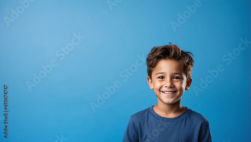 Boy smile isolated in bright blue background, backdrop with copy space