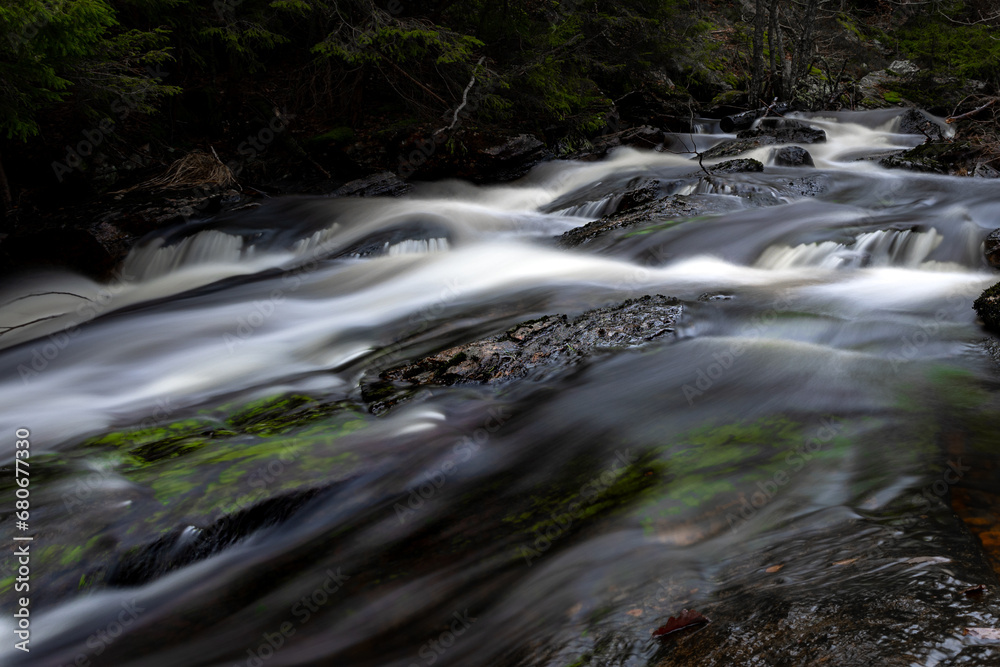 Stream of water with long exposure in dark Scandinavian forest Stream of water with long exposure in dark Scandinavian forest