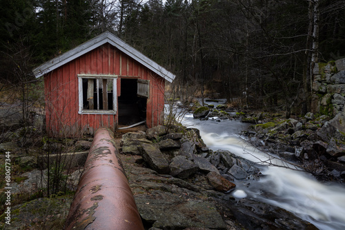 Konstfotografi Stone foundation and house of old mill with long exposure stream of water in dar