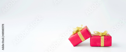 Banner, on a white background, beautiful red holiday boxes with a gold bow.  Space for copying text.  Holiday concept New Year and Christmas, Valentine's Day.  Seasonal promotions and sales.