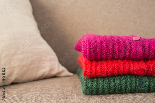 Stack of folded mohair cardigans in red, cherry and green colors. Cashmere Soft and fluffy wool. Stacked knitting patterns. Wool fabric © SNAB