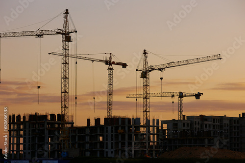 evening landscape at a construction site with sunset, cars and cranes