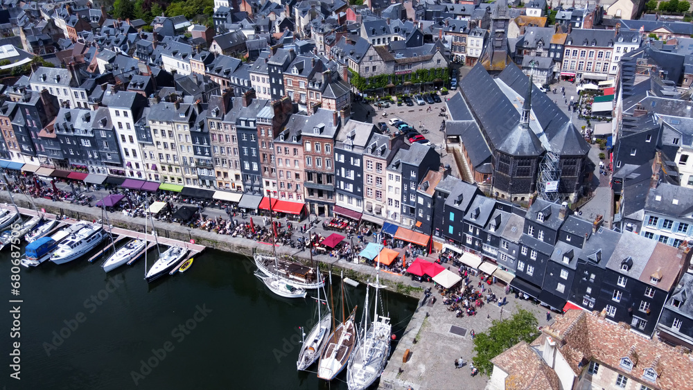 Awe Drone view  of harbor  with white sailboats of  Honfleur. Many tourists walking and sitting in cafes