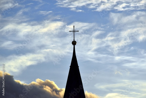 Düstere Wolken hinter einem Kirchturm photo