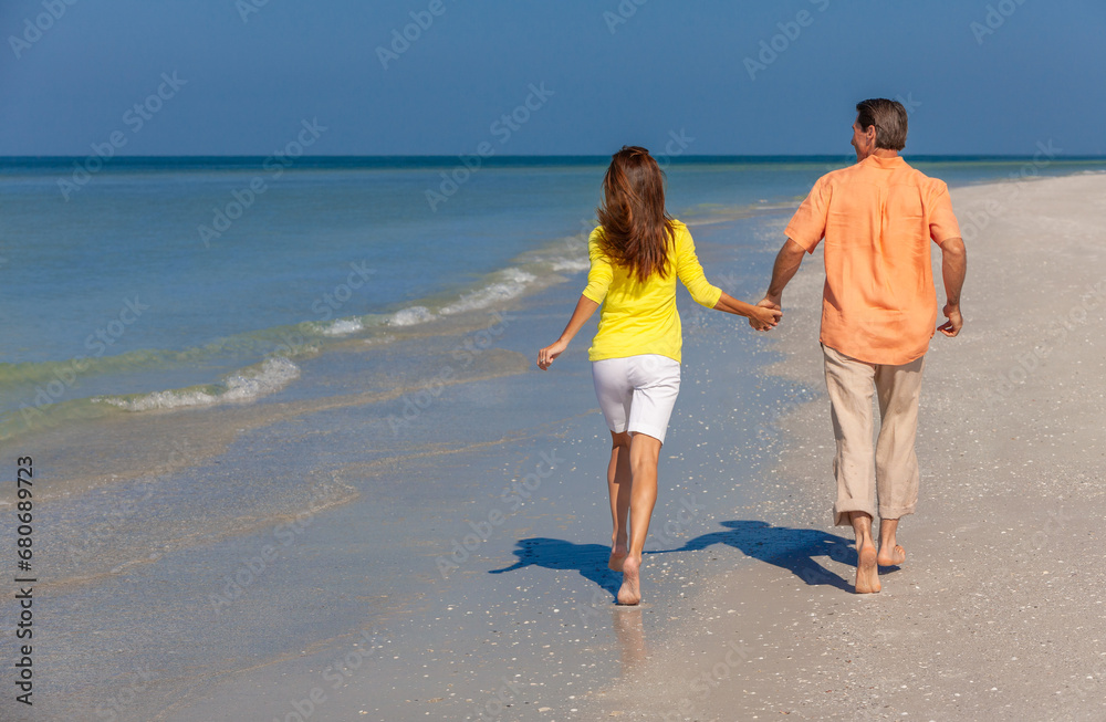Rear View of Happy Couple Running Holding Hands on A Beach Rear View of Happy Couple Running Holding Hands on A Beach