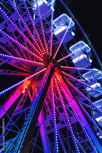 Fototapeta Naklejka Na Ścianę i Meble -  Ferris wheel also known as giant observation wheel, popular entertaining ride in amusement park, night scene low angle view