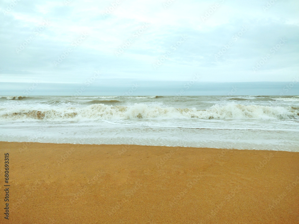 Sea wave coming on a sandy beach. Cloudy sky.  Serra, E. S. Espirito Santo, Brazil