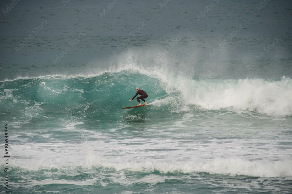 Surfer in action in the tubular waves of the Atlantic Ocean Surfer in action in the tubular waves of the Atlantic Ocean
