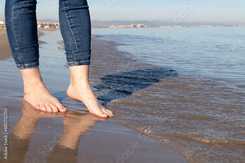feet of a woman walking barefoot on the beach © elizaveta