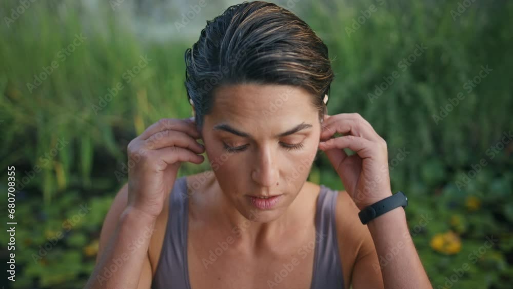 Sportive lady wearing earphones nature closeup. Woman preparing training alone Sportive lady wearing earphones nature closeup. Woman preparing training alone