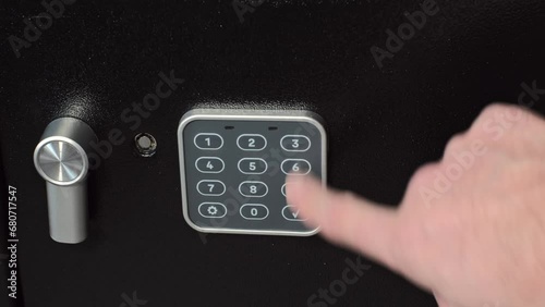 A man places a loaded revolver and a portable hard disk containing important data and information into his home safe. This scene illustrates the responsible storage of weapons 