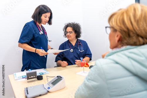 Nurse and female doctor cardiologist talking on the office with a patient