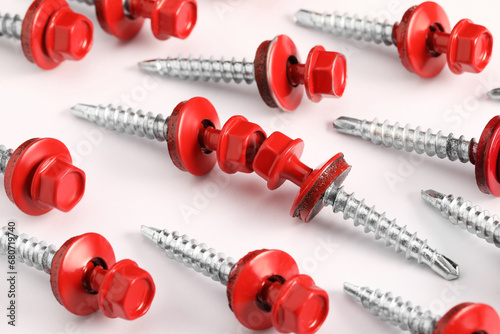 Red self-tapping screws on white background, closeup