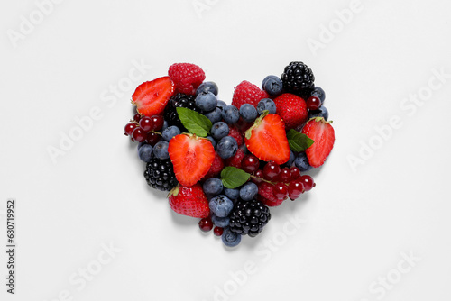 Heart made of different fresh ripe berries on white table  top view